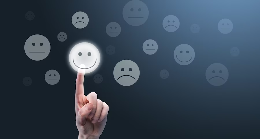 Selecionando manualmente um rosto sorridente feliz em uma tela de clique de feedback do cliente com vários emoticons.