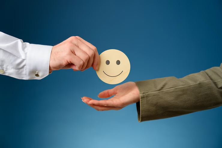 Mão dando um token de rosto sorridente para outra mão, representando a satisfação do cliente nos serviços Click to call.