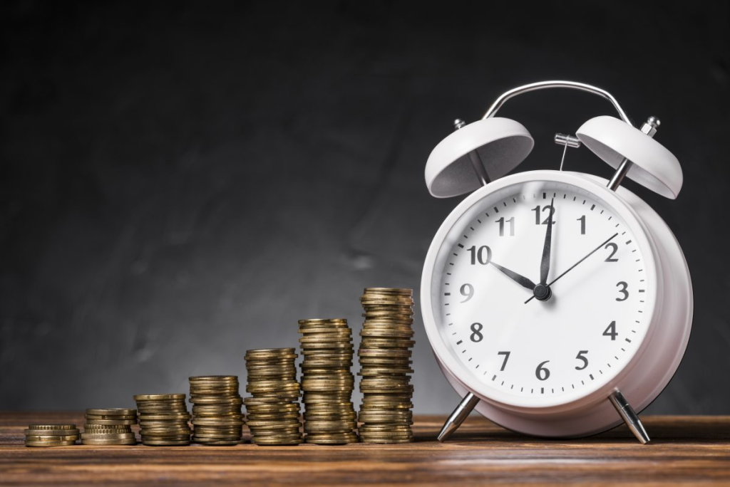 Pilhas de moedas em crescimento progressivo ao lado de um relógio despertador evocam a valiosa interconexão do tempo e dinheiro, um lembrete visual da importância da gestão do tempo nas finanças pessoais e no investimento.