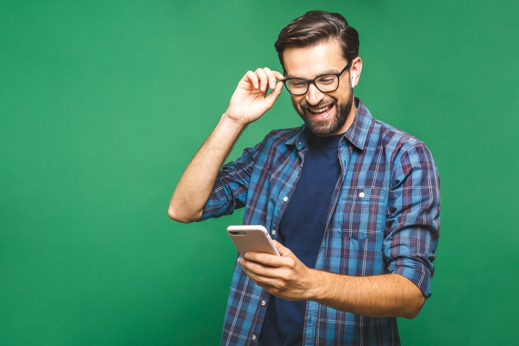  Homem entusiasmado usando seu smartphone e interagindo com o WhatsApp, demonstrando a alegria e facilidade de conectar-se com os outros através do aplicativo.