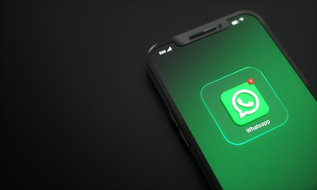 Smartphone sobre a mesa exibindo notificação do WhatsApp reflete a importância do app na comunicação instantânea e conectividade contínua.