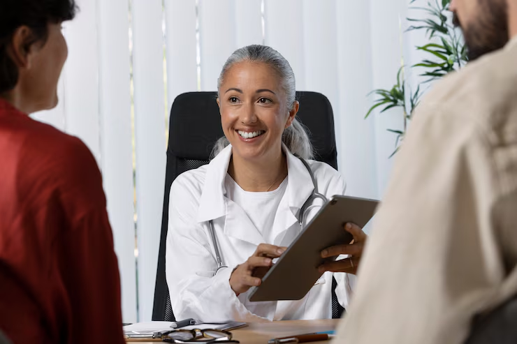 Consulta médica representando serviços de atendimento terceirizado na saúde, com uma profissional sorridente conversando com pacientes.
