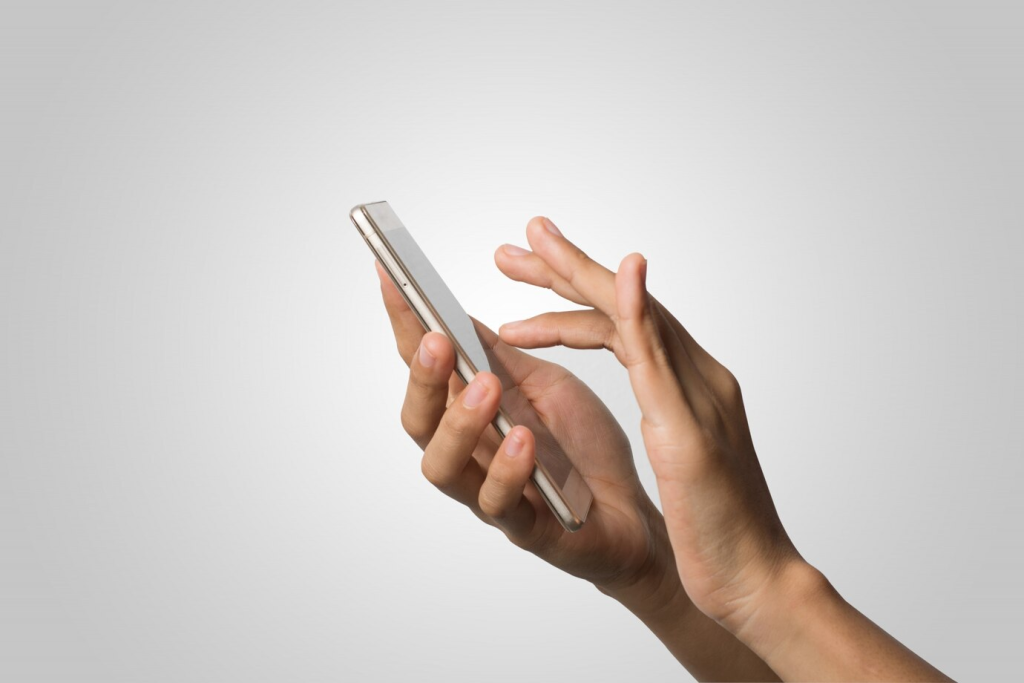 Mãos de usuário navegando em um smartphone, simbolizando a praticidade e eficiência do WhatsApp para comunicação rápida e efetiva.
