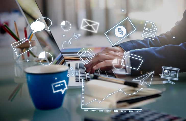 Uma pessoa trabalhando em um laptop rodeada por ícones representando comunicação, finanças e análise de dados, destacando a multifuncionalidade da gestão empresarial moderna.