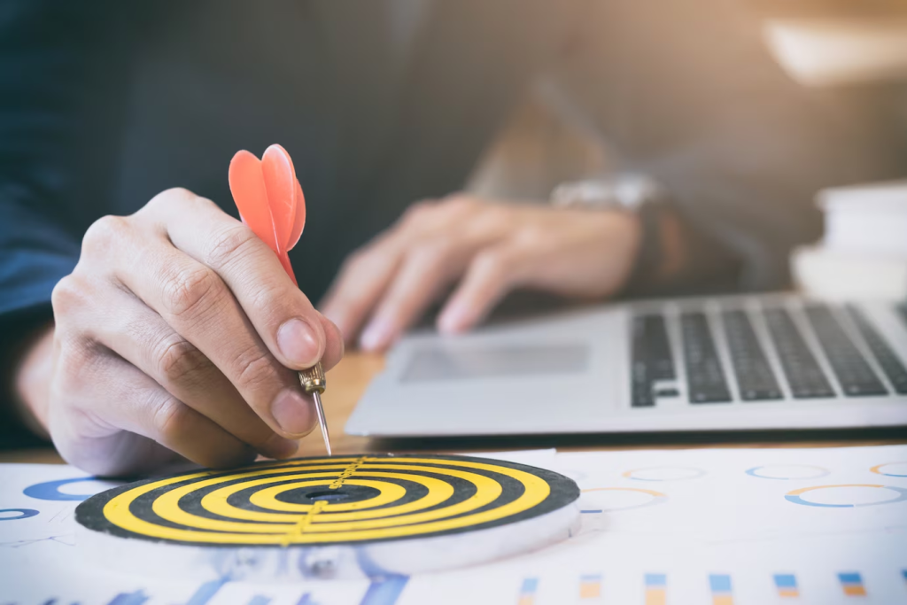 Empresário posicionando uma flecha em um alvo sobre gráficos de desempenho, simbolizando estratégias de negócios e objetivos alcançados.