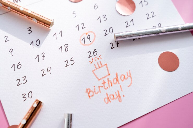 Calendário de planejamento com uma data de aniversário marcada, acompanhado de uma caneta, enfatizando a organização de eventos pessoais importantes.