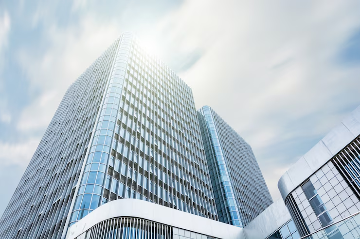 Fachada de um moderno edifício de escritórios com design contemporâneo, refletindo inovação e ambiente corporativo.