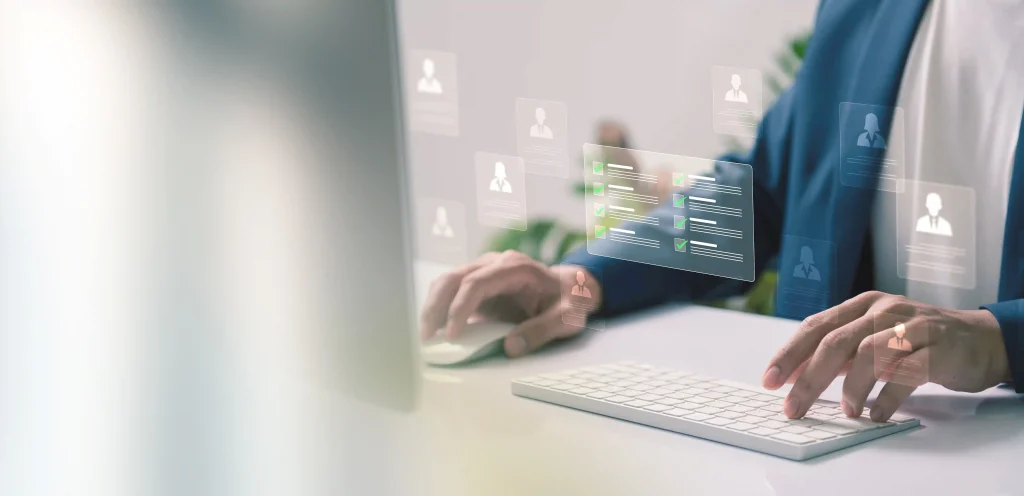 Pessoa usando computador com interface digital simulando um CRM para WhatsApp, representando a integração de contatos e gestão no sistema da Tallk.me.