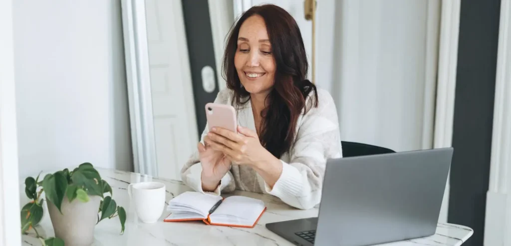 Mulher recebendo atendimento multicanal via celular e computador