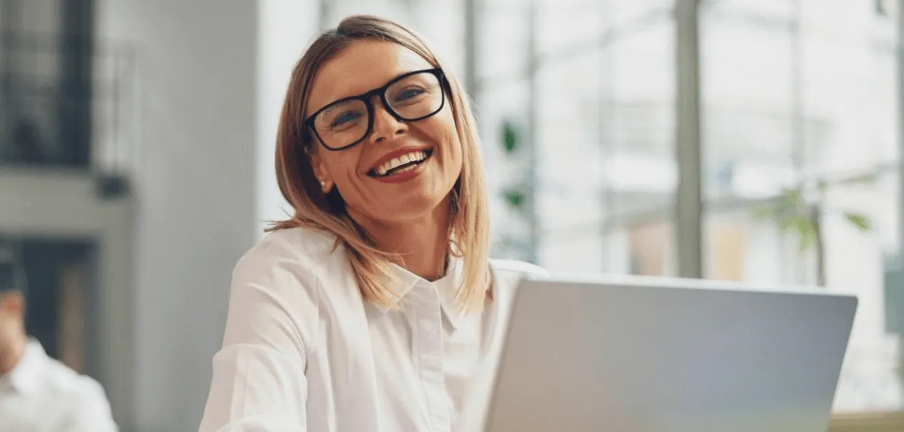 Mulher feliz ao atender cliente com foco em experiência e técnicas de atendimento ao cliente