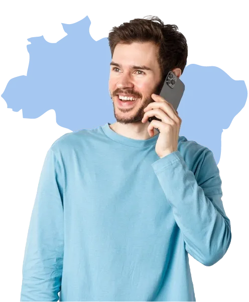 Homem sorridente usando um celular, vestindo uma blusa azul clara, com um mapa do Brasil em tom azul claro ao fundo