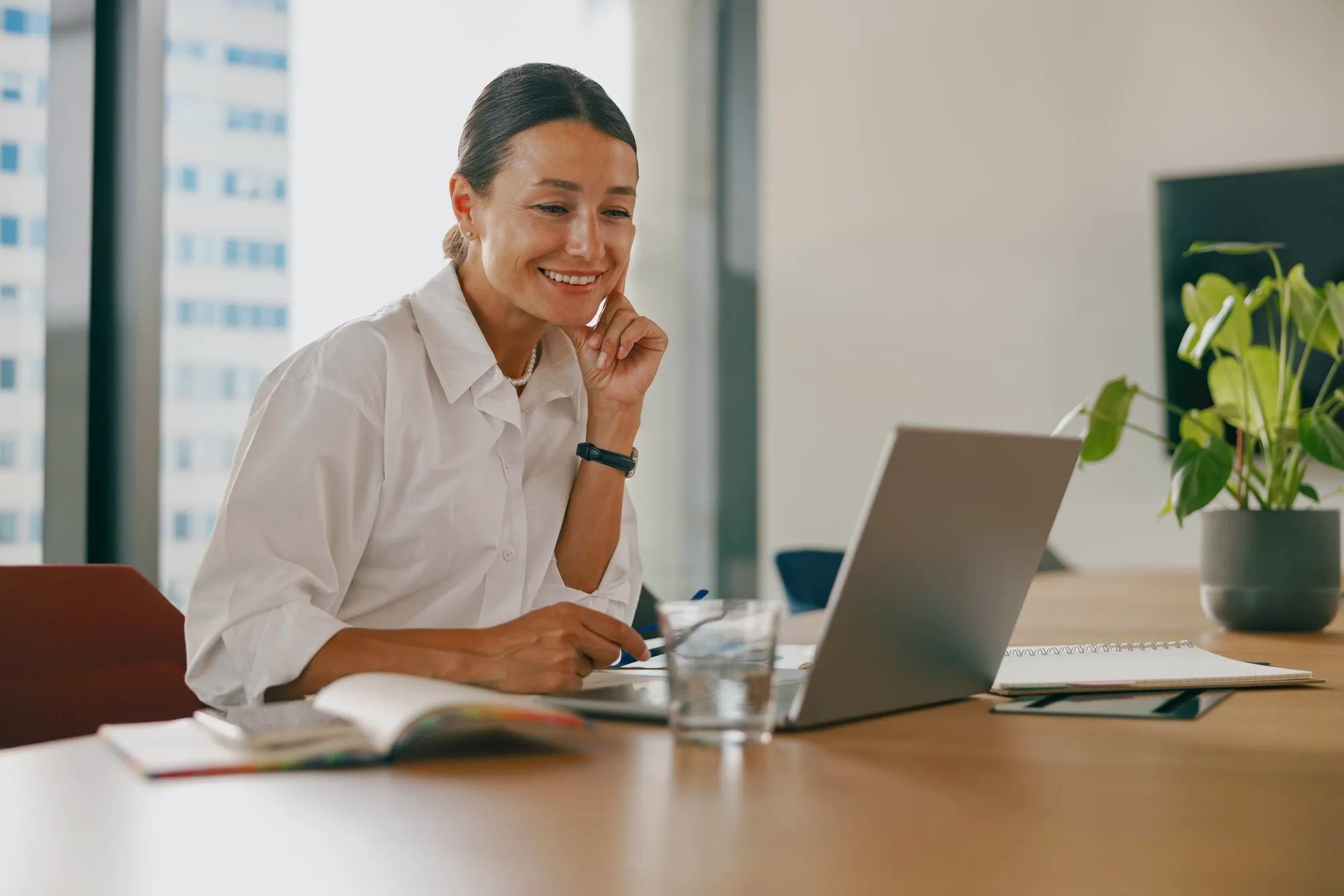 Mulher usando notebook no escritório para configurar número virtual no WhatsApp Business