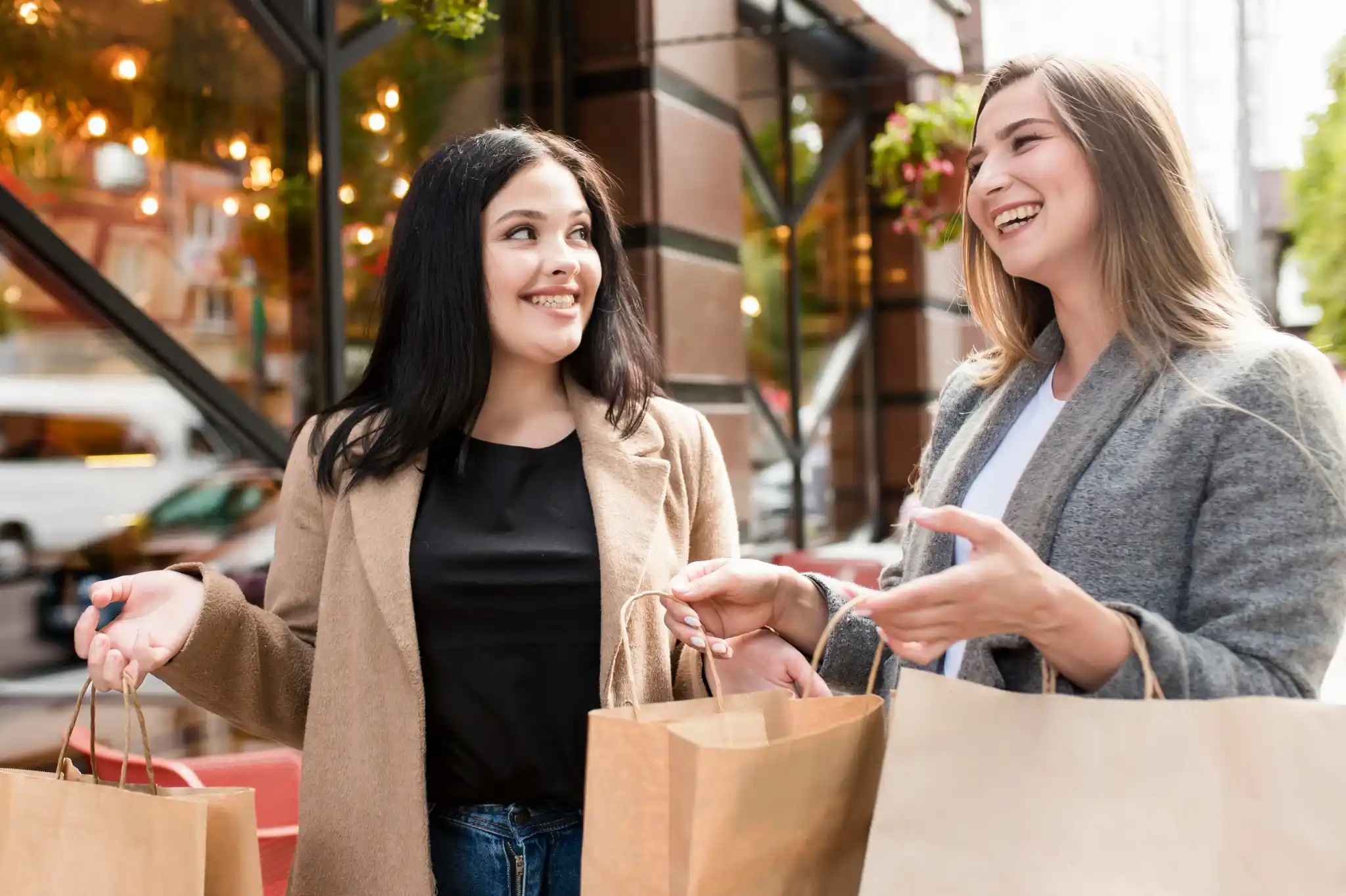 Duas mulheres felizes segurando sacolas de compras após aproveitar promoções da Black Friday 2025